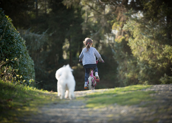 Bambina in bici con cane